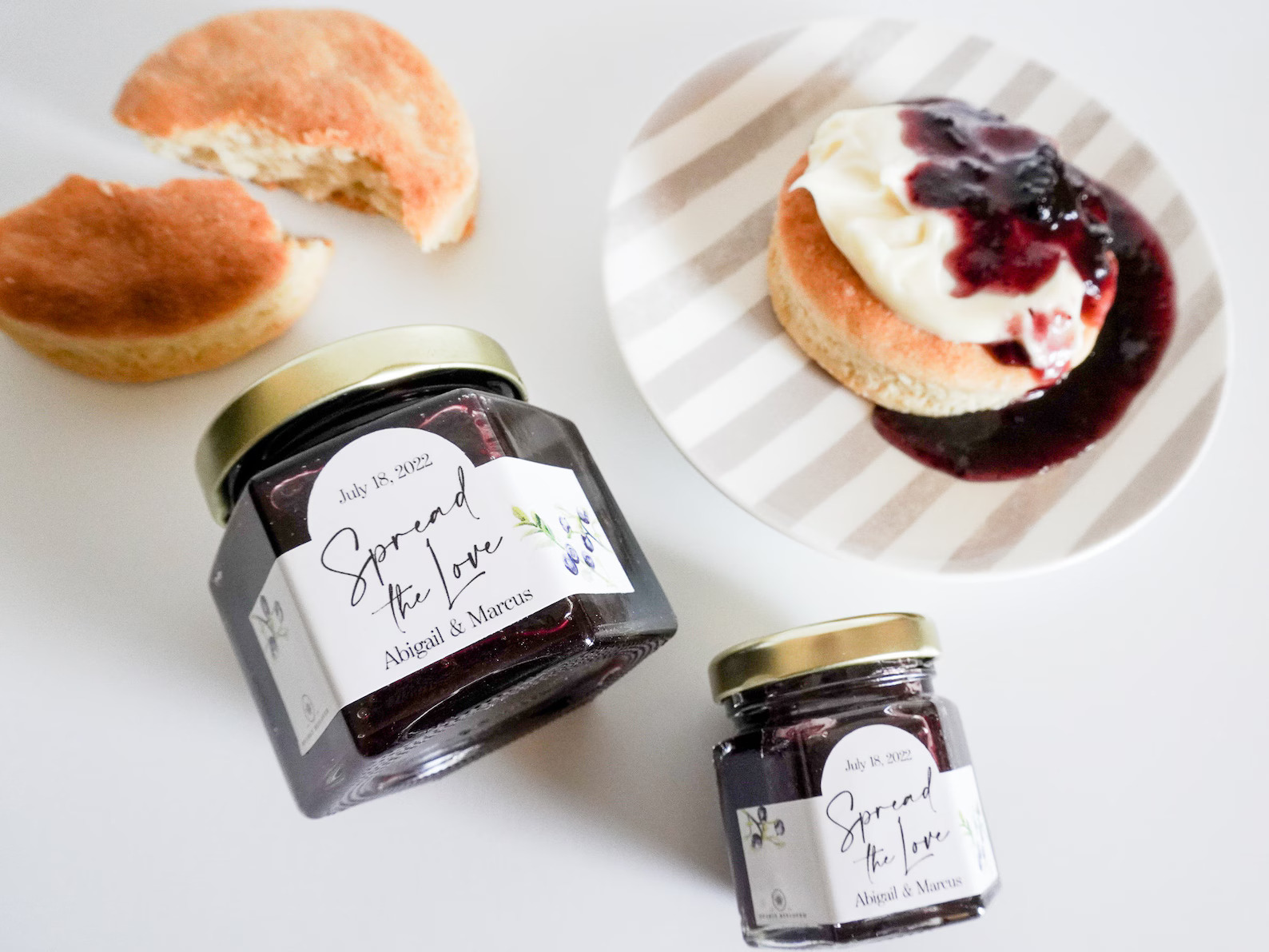 Pohár ručne vyrábaného bobuľového džemu so scone a smotanou